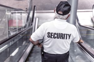 man-wearing-security-uniform-riding-escalator